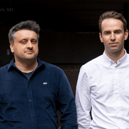 Vlad Gulu and Tom Garnett, founders of Refute posing for a photo outside in an urban setting.